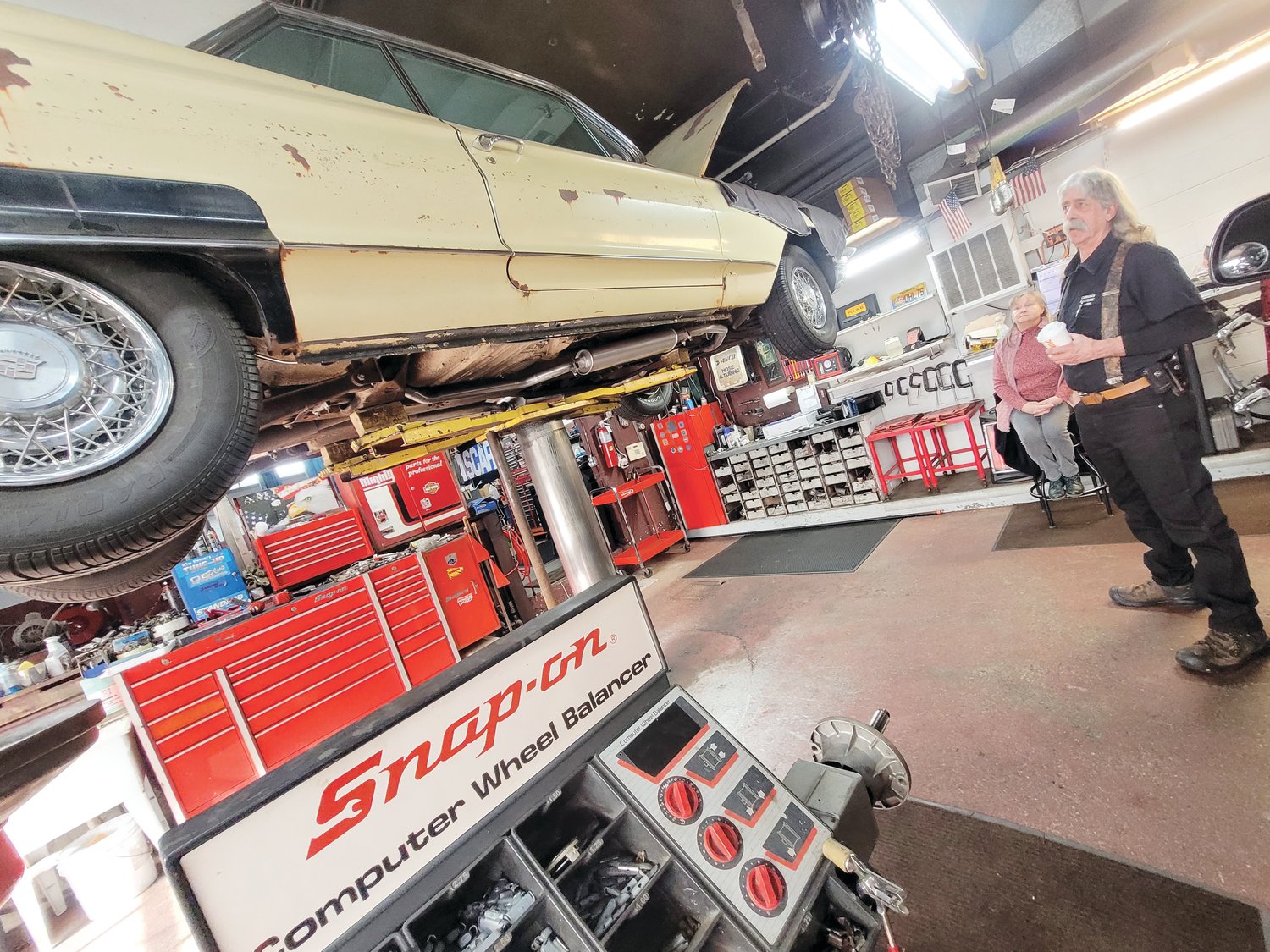 CLINIC CLOSES: Dave Carrara has been twisting wrenches in Johnston for more than 40 years. On May 12, he plans to close his Atwood Avenue shop, Carrara’s Auto Clinic, forever. Here he stands underneath a ’62 Cadillac Coup deVille he’s restoring for a client. Carrara plans to spend more time hunting, fishing and playing with his grandchildren.